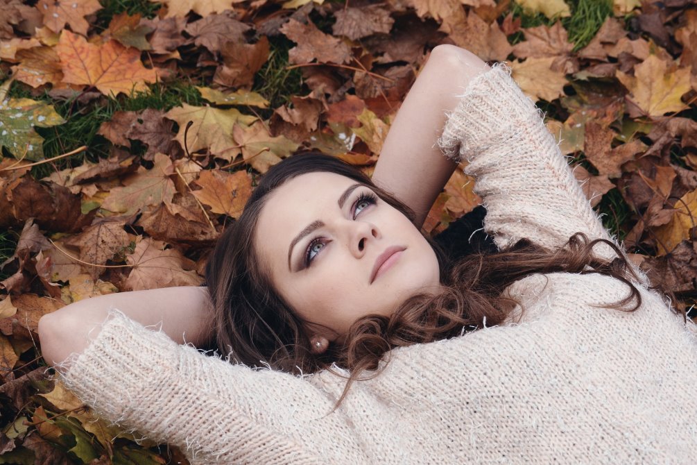 Woman lying on autumn leaves