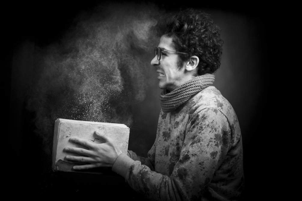 Man holding a dusty book